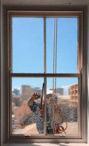 using squeegee to clean window